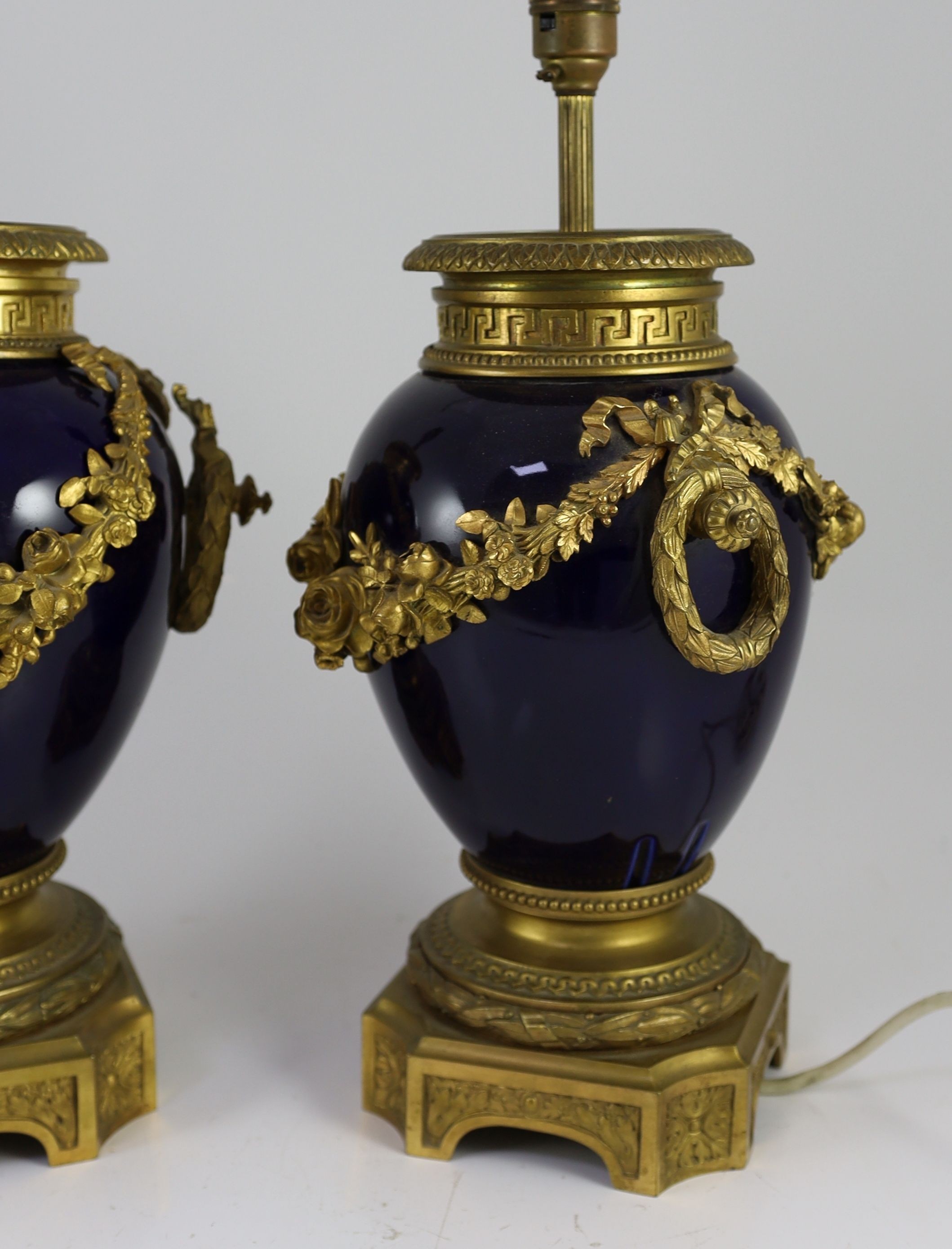 A pair of Louis XVI style ormolu mounted bleu du roi porcelain table lamps, width 23cm height 40cm